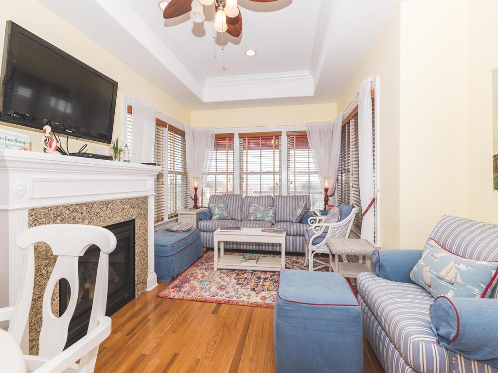 image Spacious living area with natural light and a mounted TV for entertainment.