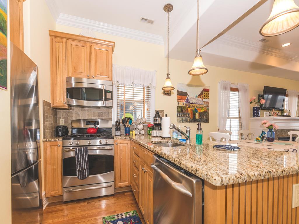 image Fully equipped kitchen with granite countertops and stainless steel appliances.