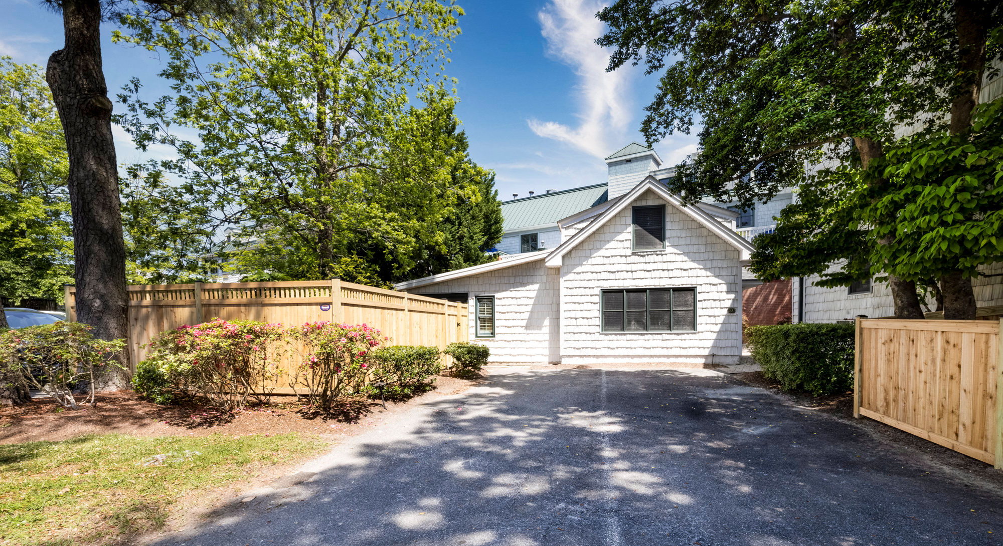 image A charming exterior with lush greenery and a private driveway welcomes you to a peaceful retreat.
