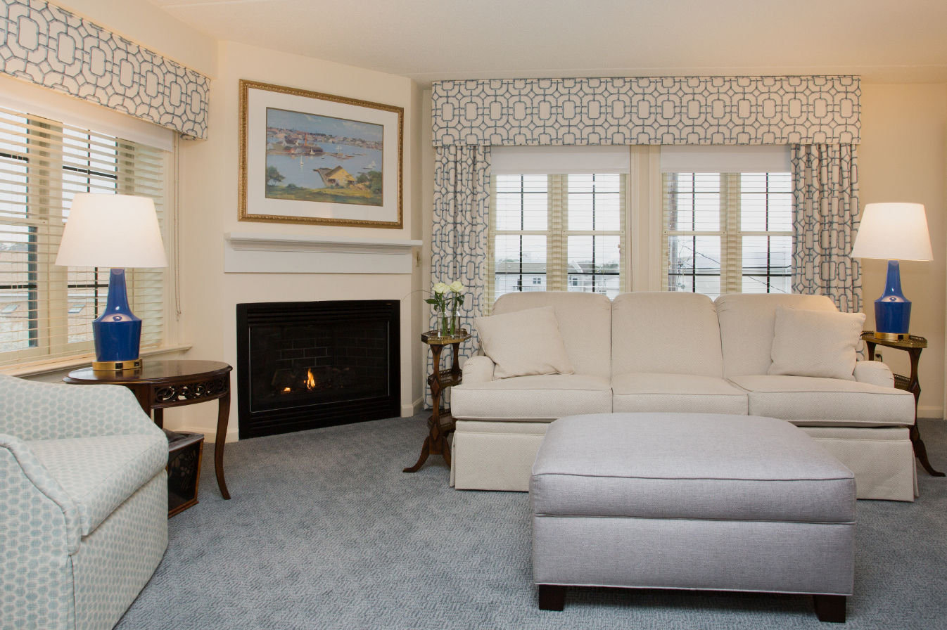 image Elegant living space with a charming fireplace, plush seating, and natural light streaming through large windows.
