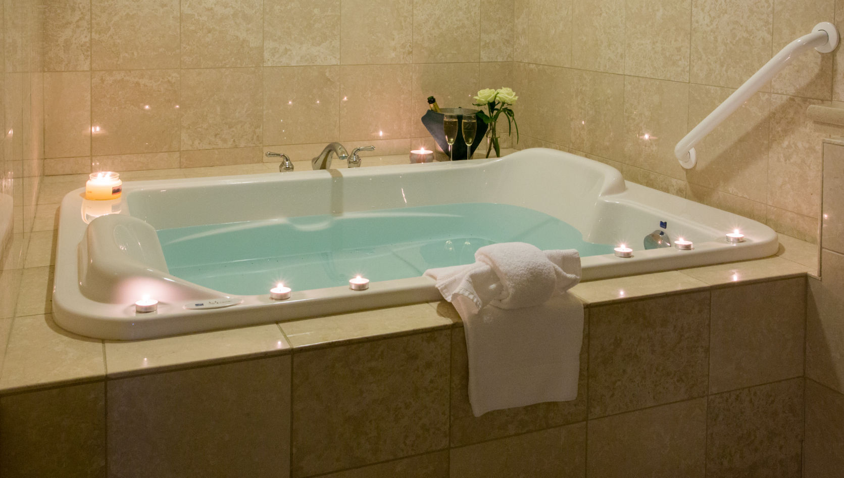image Unwind in a soothing spa tub surrounded by soft candlelight for a truly relaxing experience.