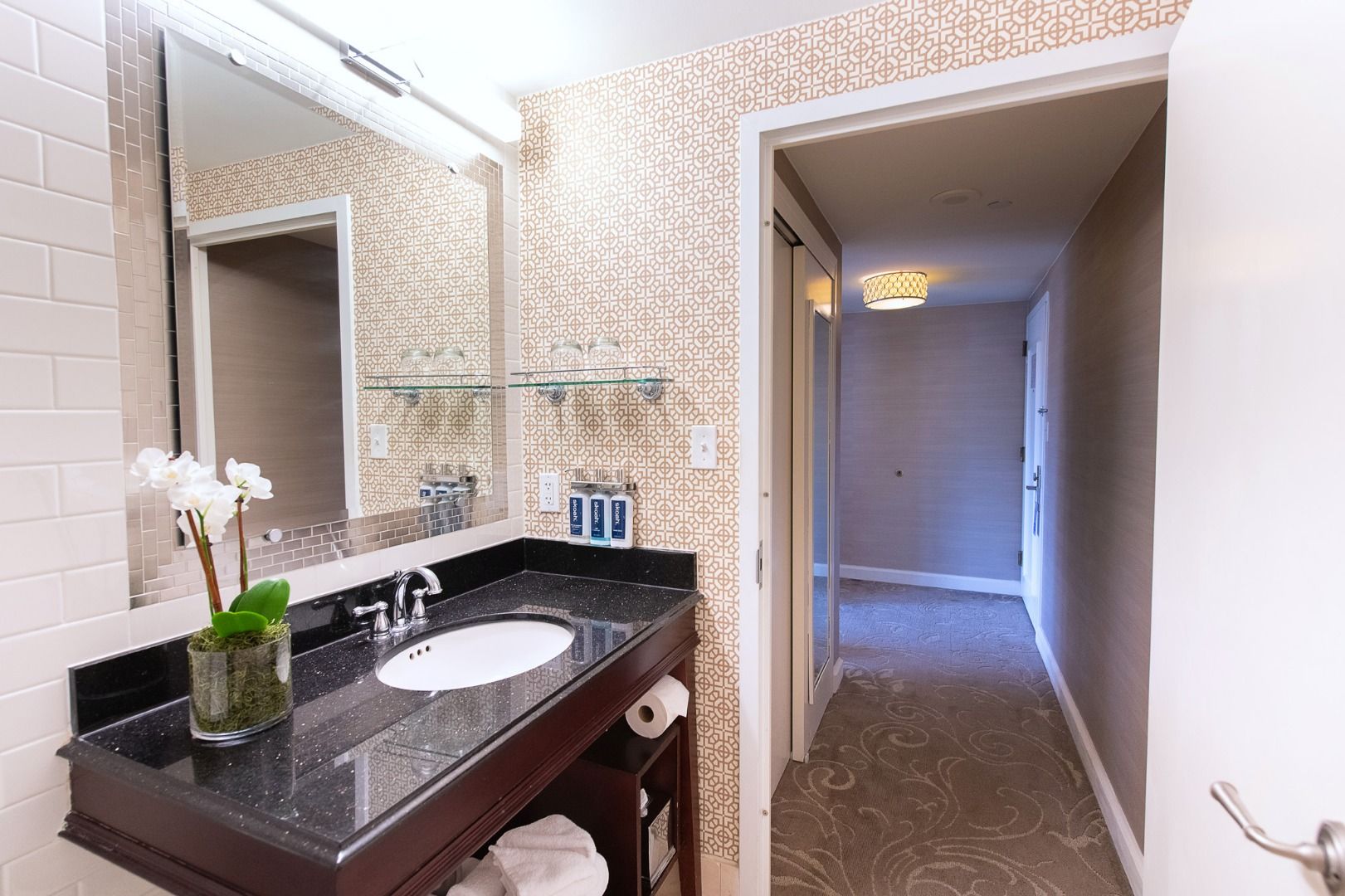 image Elegant and modern bathroom, featuring sleek countertops, warm lighting, and thoughtful amenities for a refreshing stay.