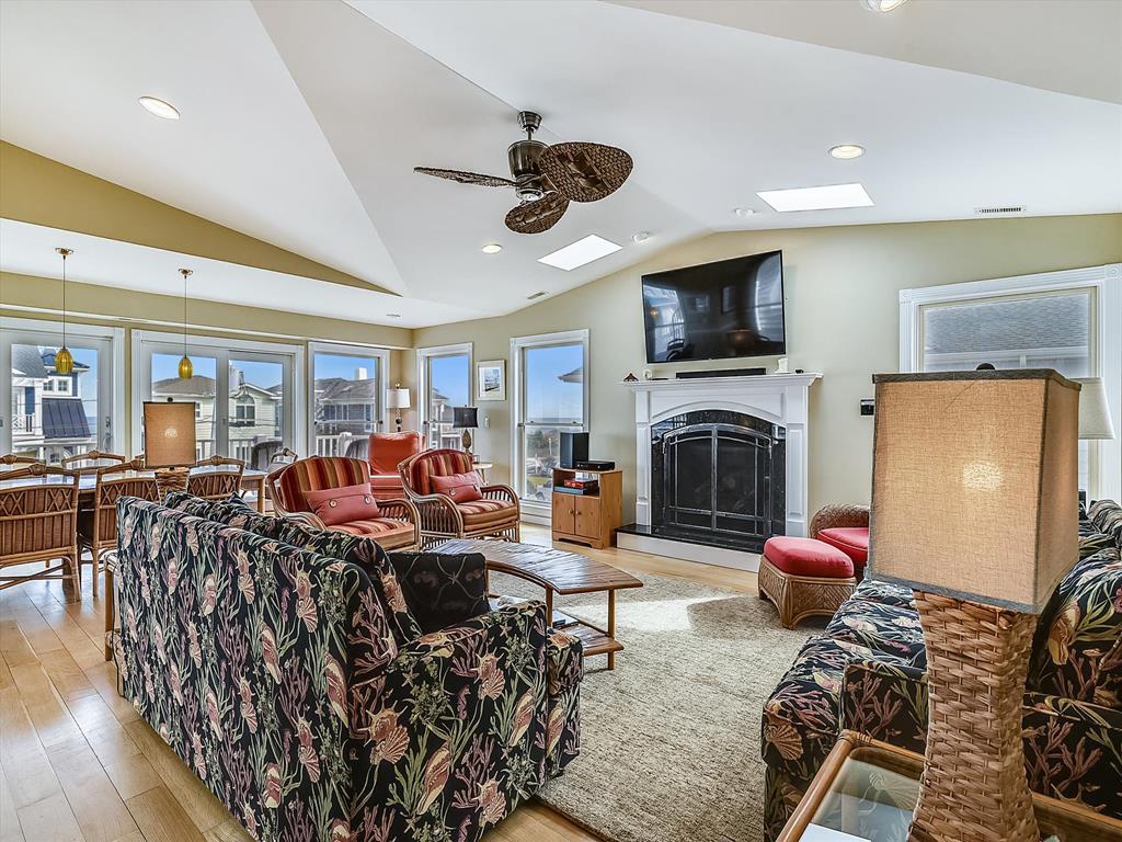 image Cozy living room with comfortable seating, a ceiling fan, and an entertainment center.