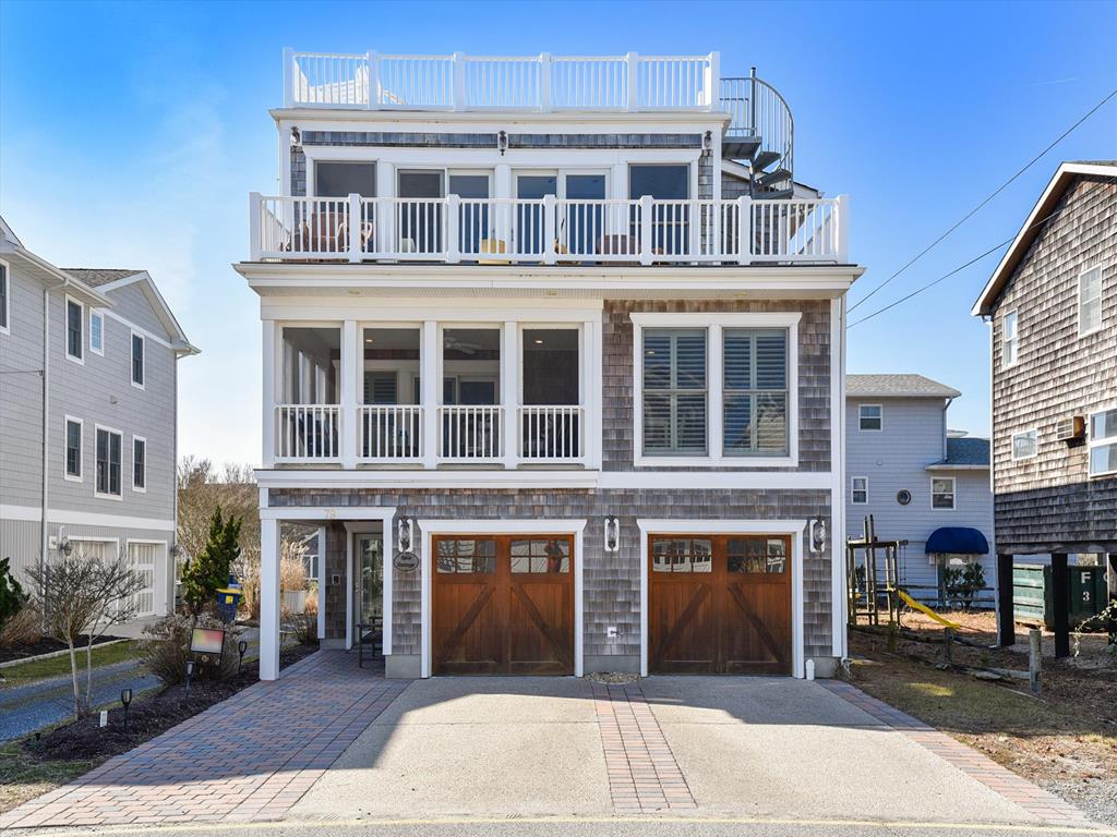 image Stunning multi-level beach home with a spacious driveway and modern coastal design.
