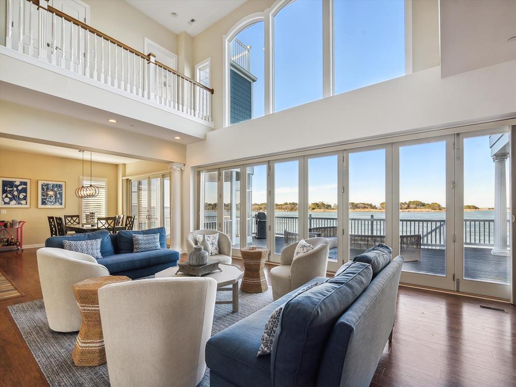 image Enjoy the serene bayfront atmosphere from the expansive windows of this bright living space, perfect for entertaining with stylish decor and comfortable seating.