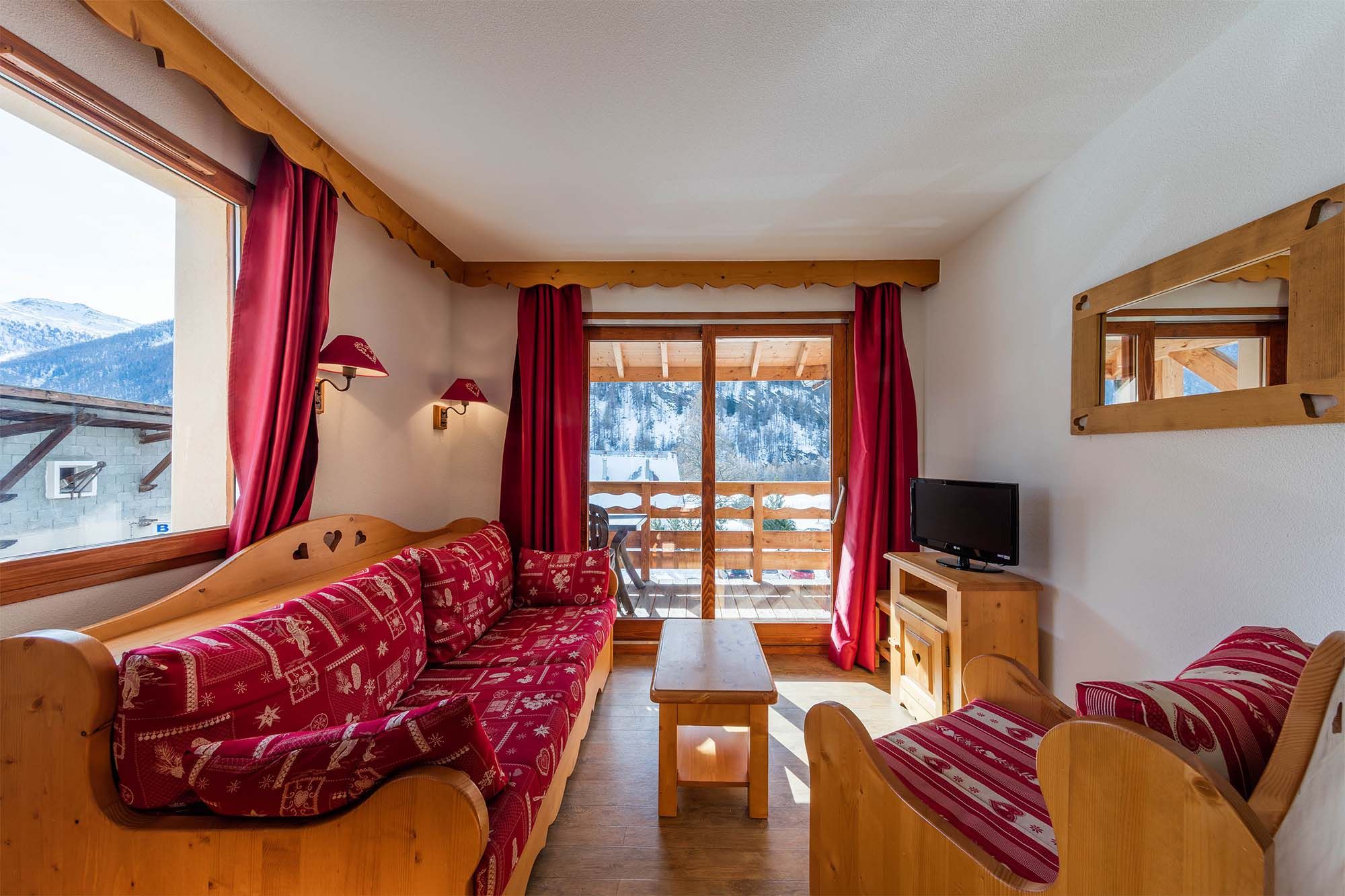 image A bright and cozy living room with large windows, offering a stunning view of the surrounding mountains.