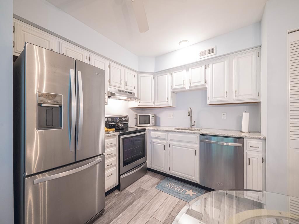 image Sleek kitchen with stainless steel appliances and ample storage space.Stainless steel appliances and white cabinetry give a sleek, updated feel.