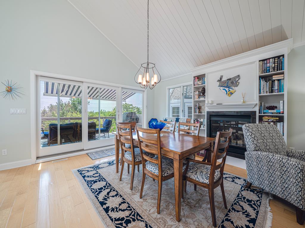 image Bright and airy, the elegant dining area offers a welcoming ambiance with large windows revealing outdoor seating and a charming fireplace.