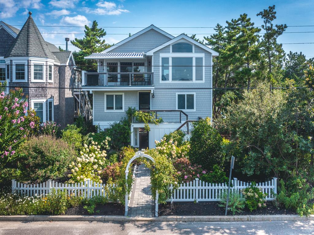 image This charming coastal home features lush landscaping, a welcoming front entry, and an inviting upper deck perfect for enjoying ocean views.