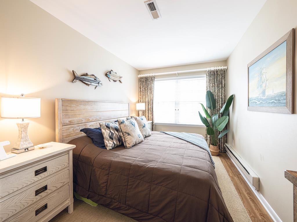 image Spacious master bedroom with a king bed, natural light, and a cozy seating area for relaxation.