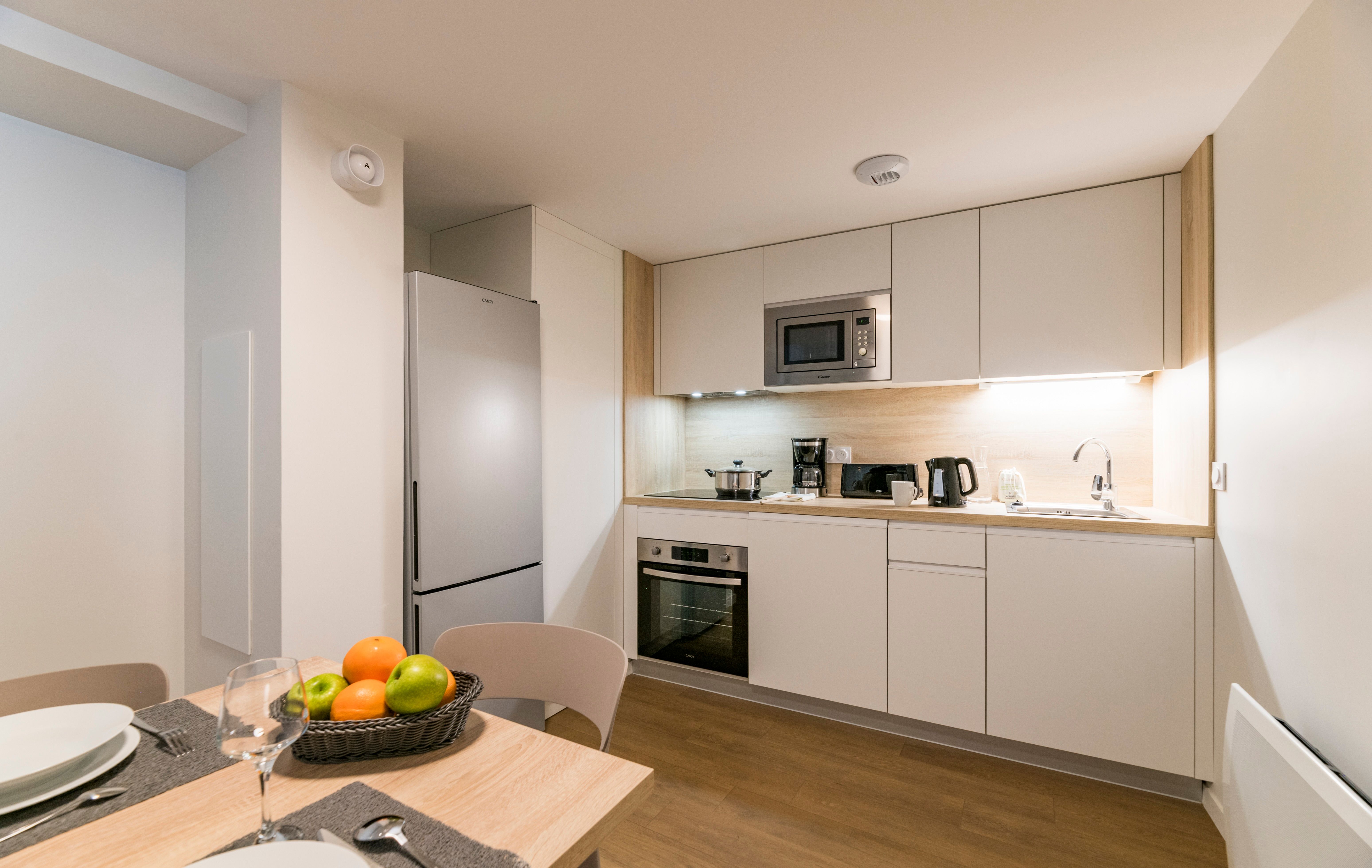 image Cook your favorite meals in this modern kitchen, equipped with sleek appliances and a welcoming dining space, ideal for family gatherings or intimate dinners.