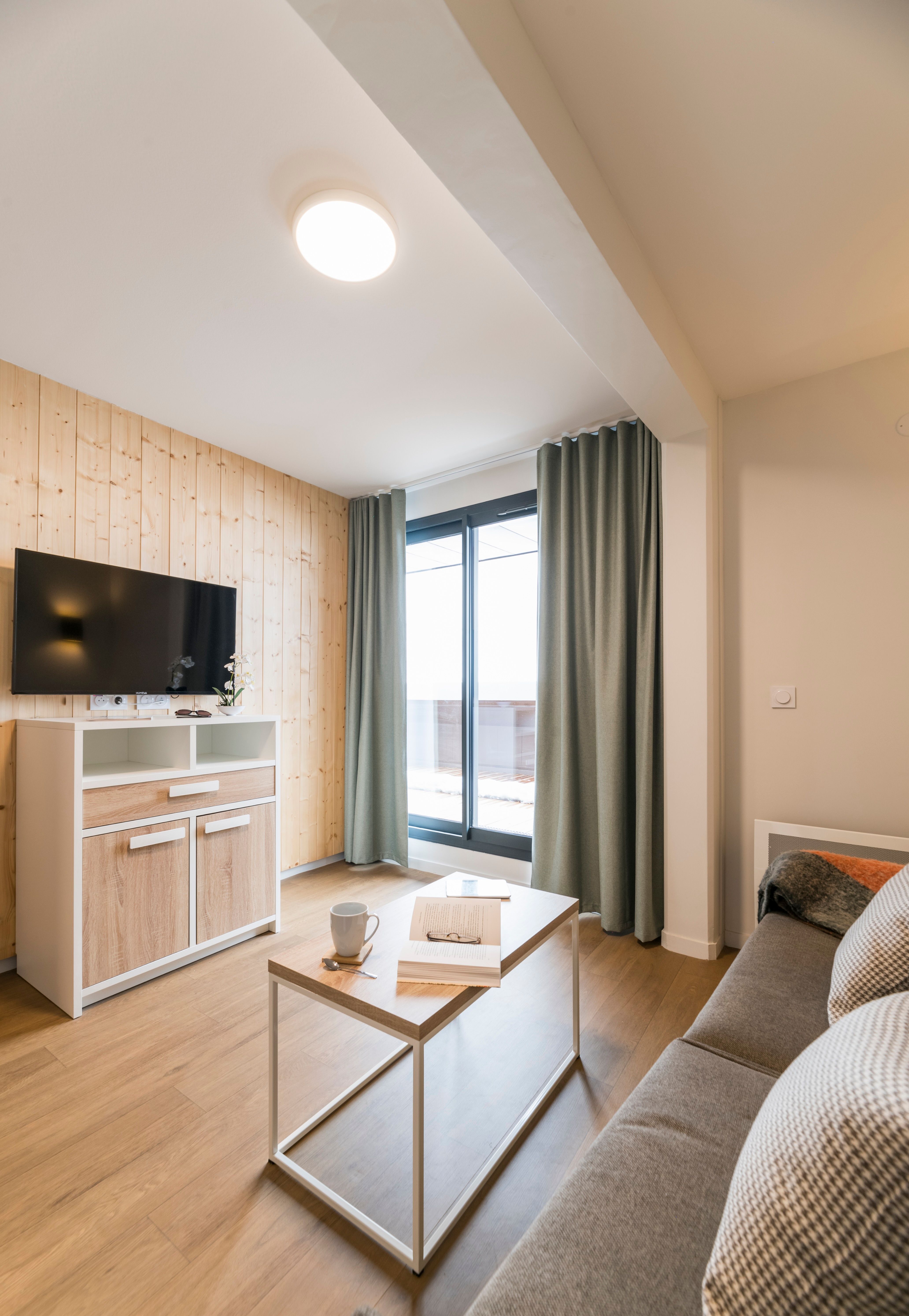 image Unwind with your favorite book or coffee in this inviting living space, featuring stylish furnishings and a seamless indoor-outdoor flow to your private balcony.