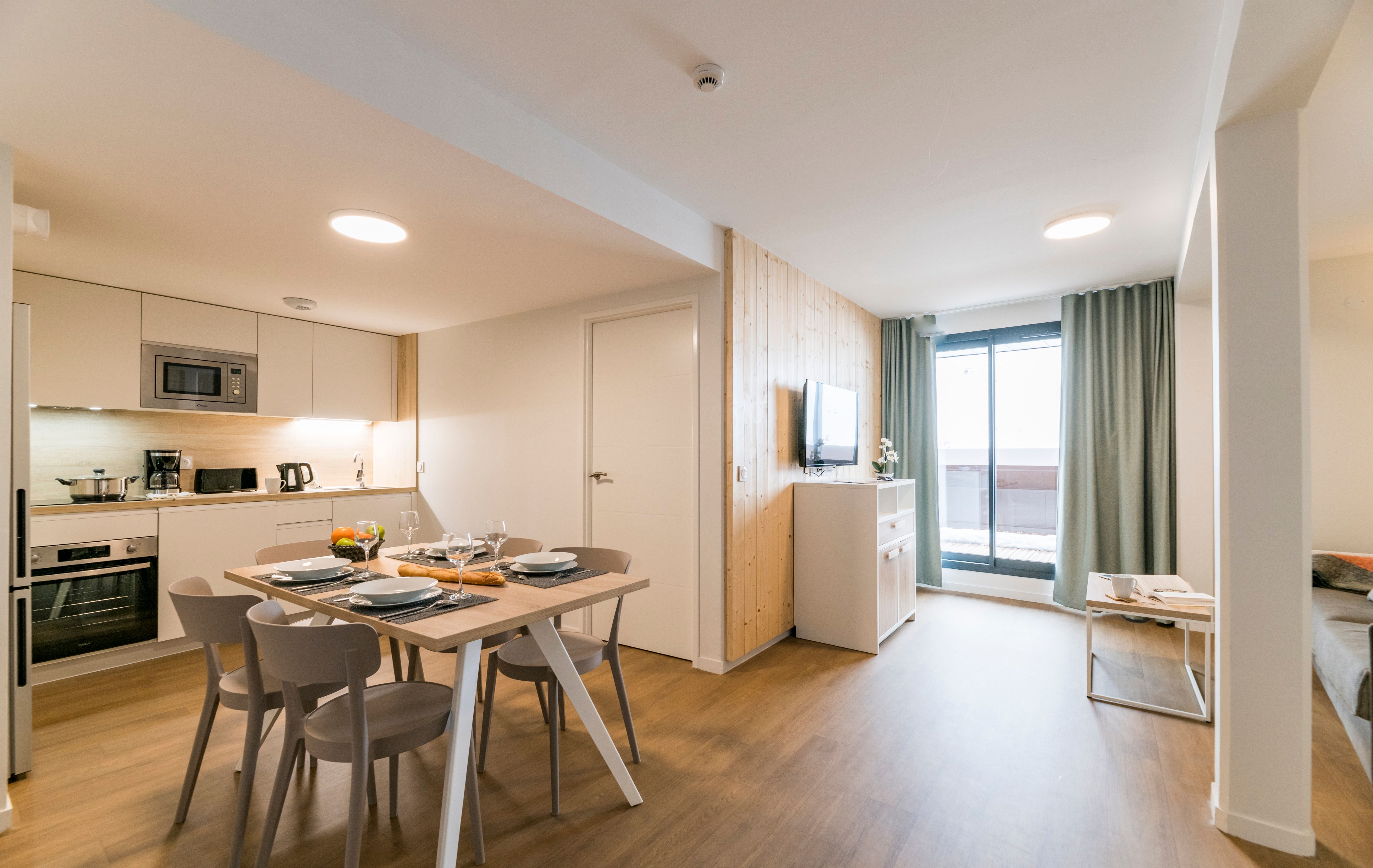 image Gather around the beautifully set dining table in this well-appointed apartment, a perfect blend of modern décor and rustic charm, making every meal feel special.