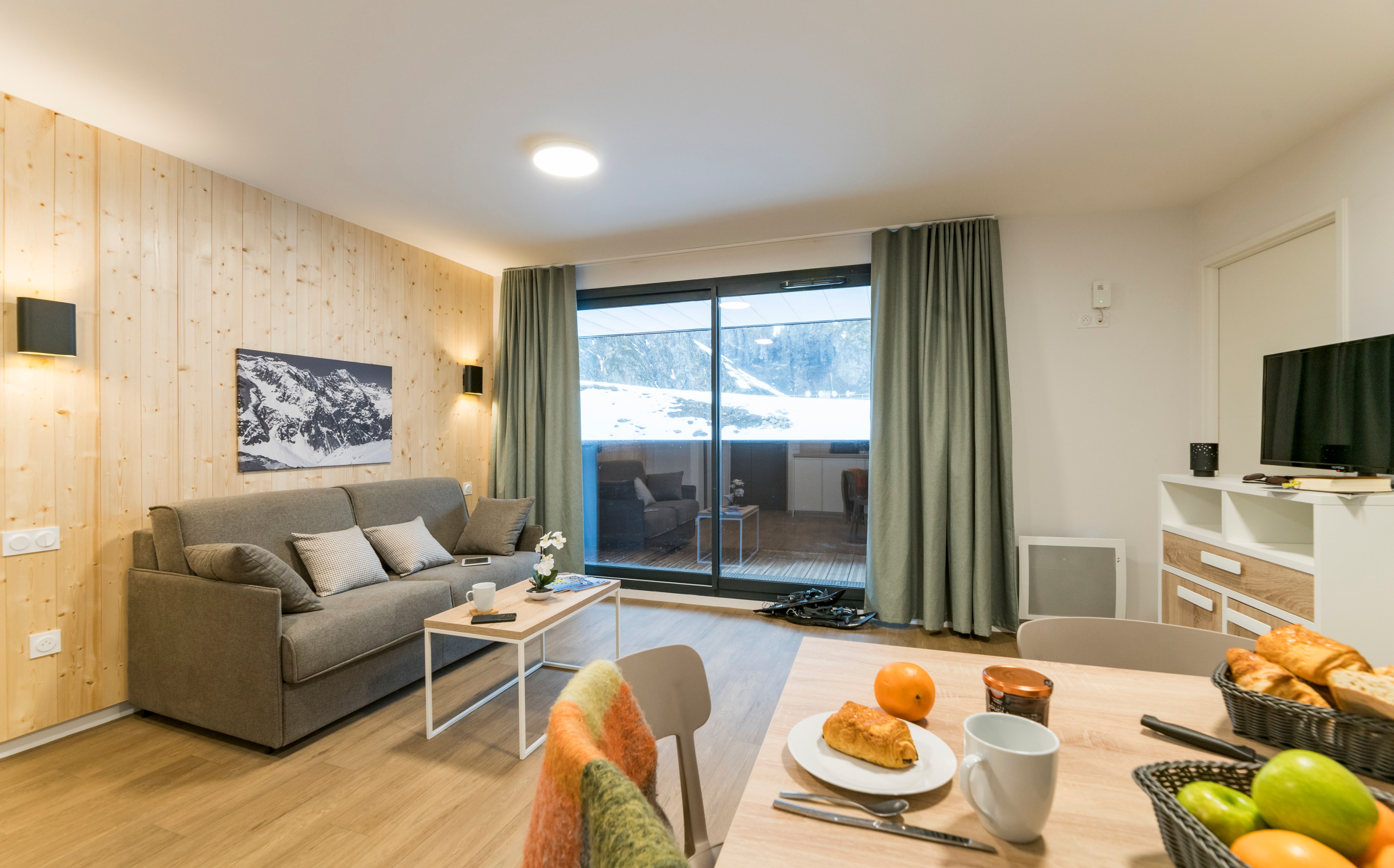 image Relax in the cozy living room adorned with natural wood accents and inviting mountain views, perfect for unwinding after a day of adventure.