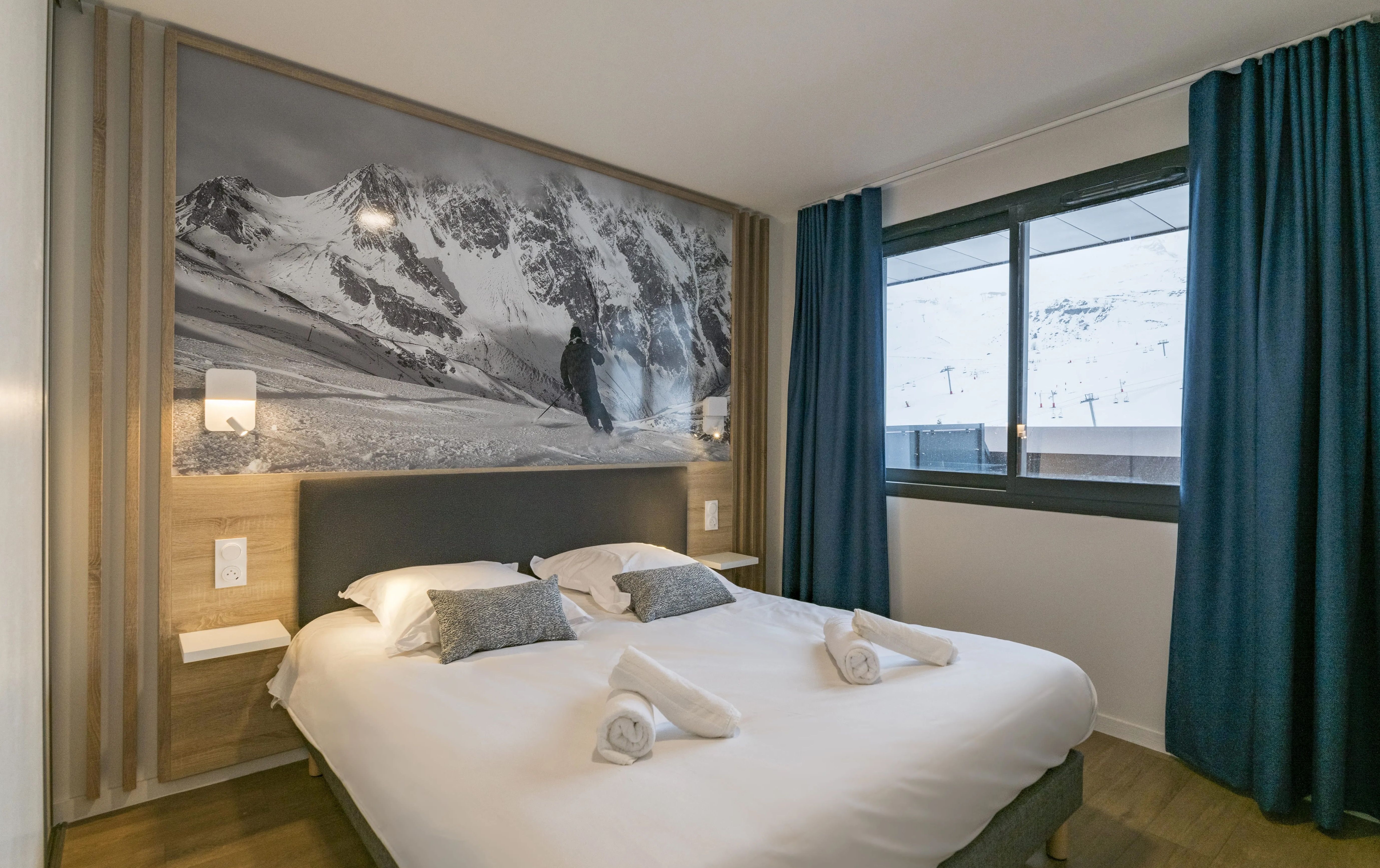 image Unwind in the inviting bedroom adorned with stunning mountain views, featuring plush bedding and elegant decor to ensure a restful night's sleep after outdoor adventures.