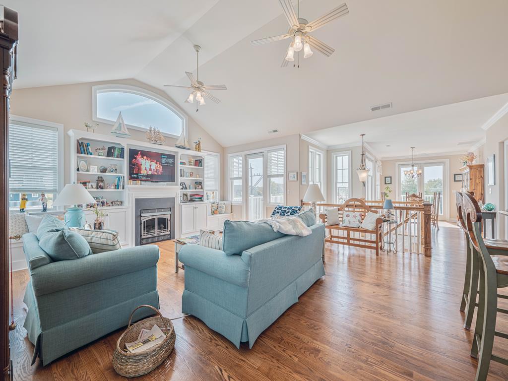 image Open-concept living space with elegant hardwood floors and large windows offering scenic views.
