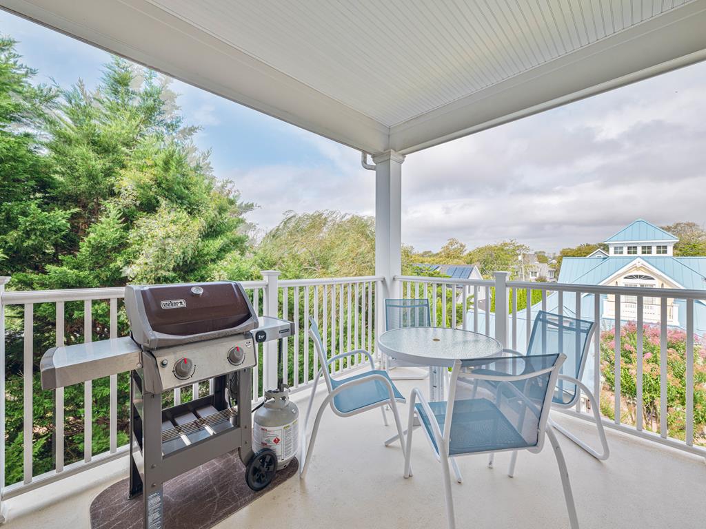 image Covered balcony with a BBQ grill and outdoor seating—ideal for cookouts with a view.