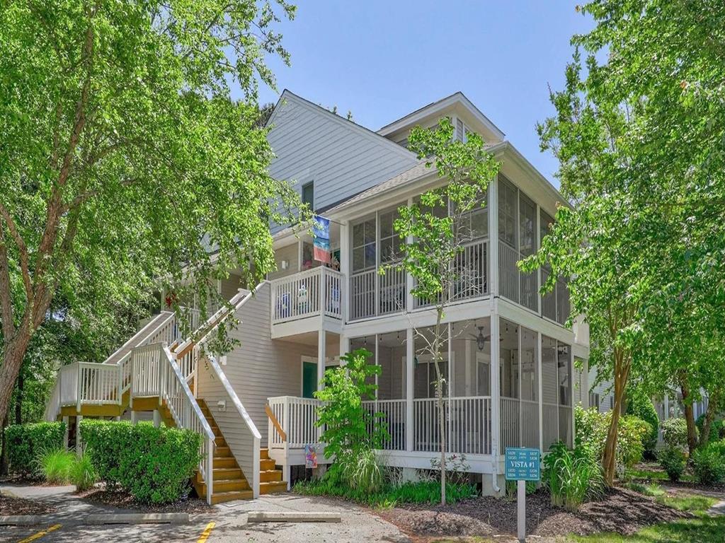 image Beautifully designed condo with a screened-in porch, nestled among lush greenery for a peaceful retreat.