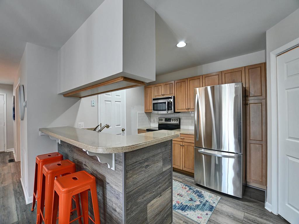 image A modern kitchen with bar seating and an open layout, ideal for entertaining guests.