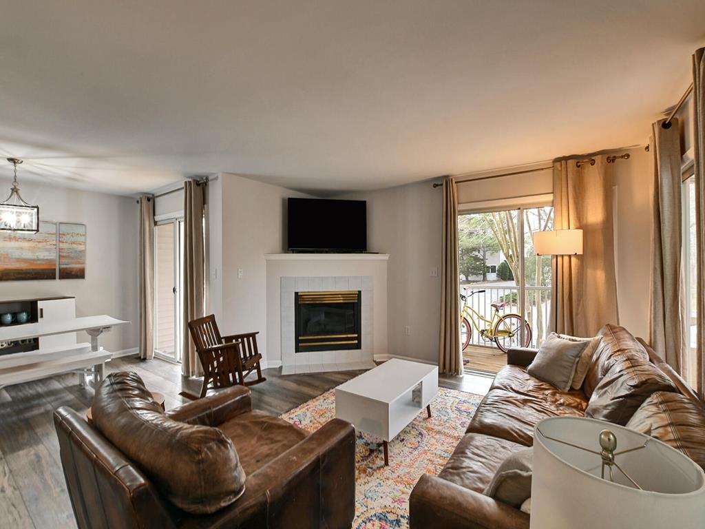 image A warm and inviting living room featuring plush leather seating, a cozy fireplace, and natural light streaming through large windows. The perfect space to unwind after a day at the beach.