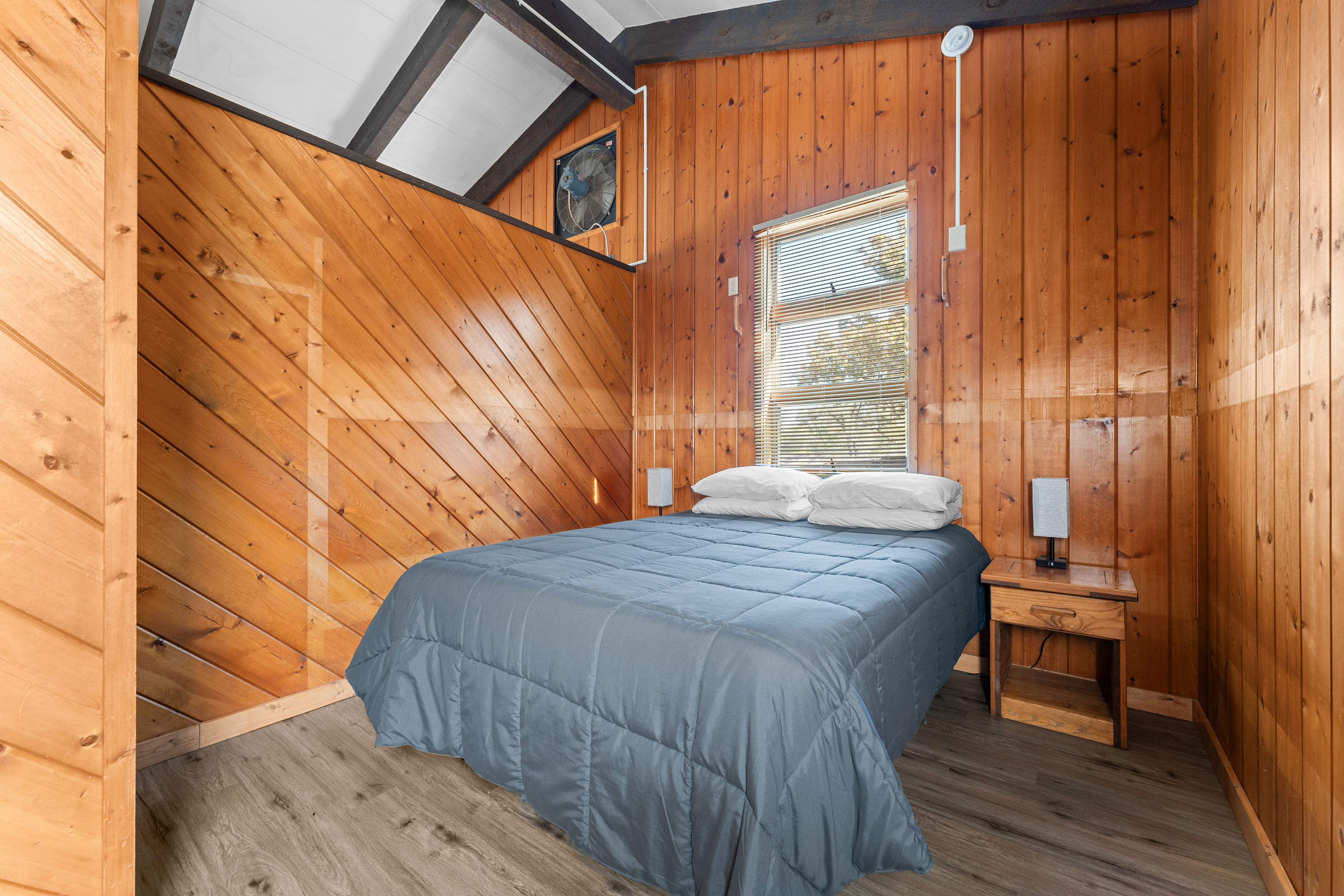 image Cozy bedroom with rustic wood paneling and a comfortable queen bed—perfect for a restful night after a day of exploring.