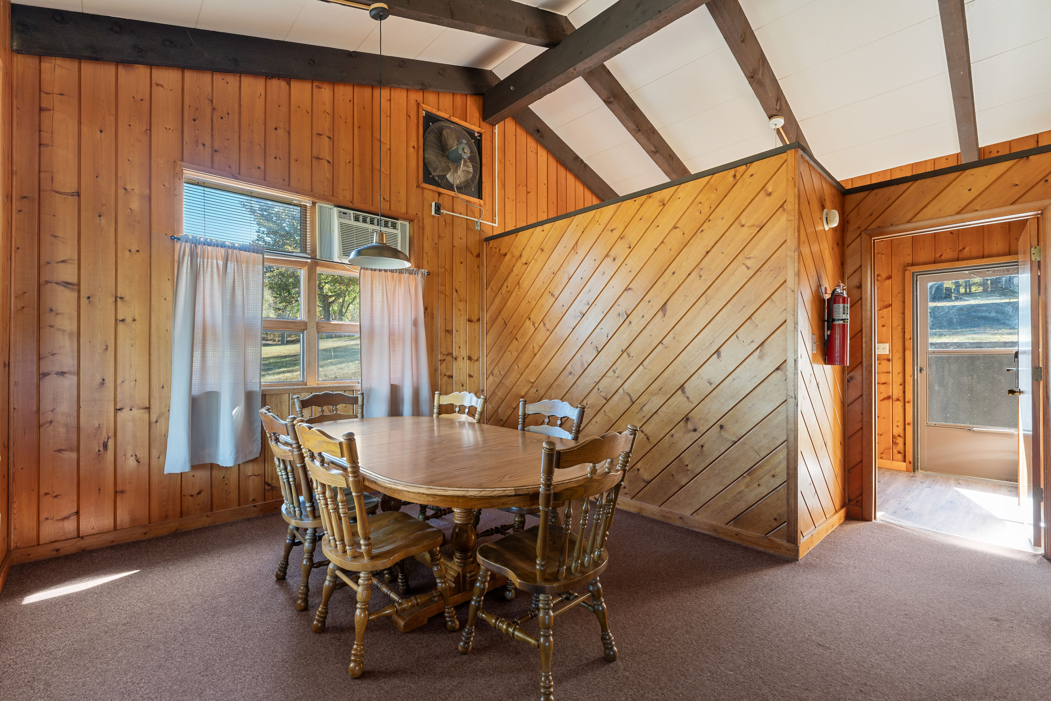 image Inviting dining area with vaulted ceilings and large windows, offering scenic views and a warm cabin ambiance.
