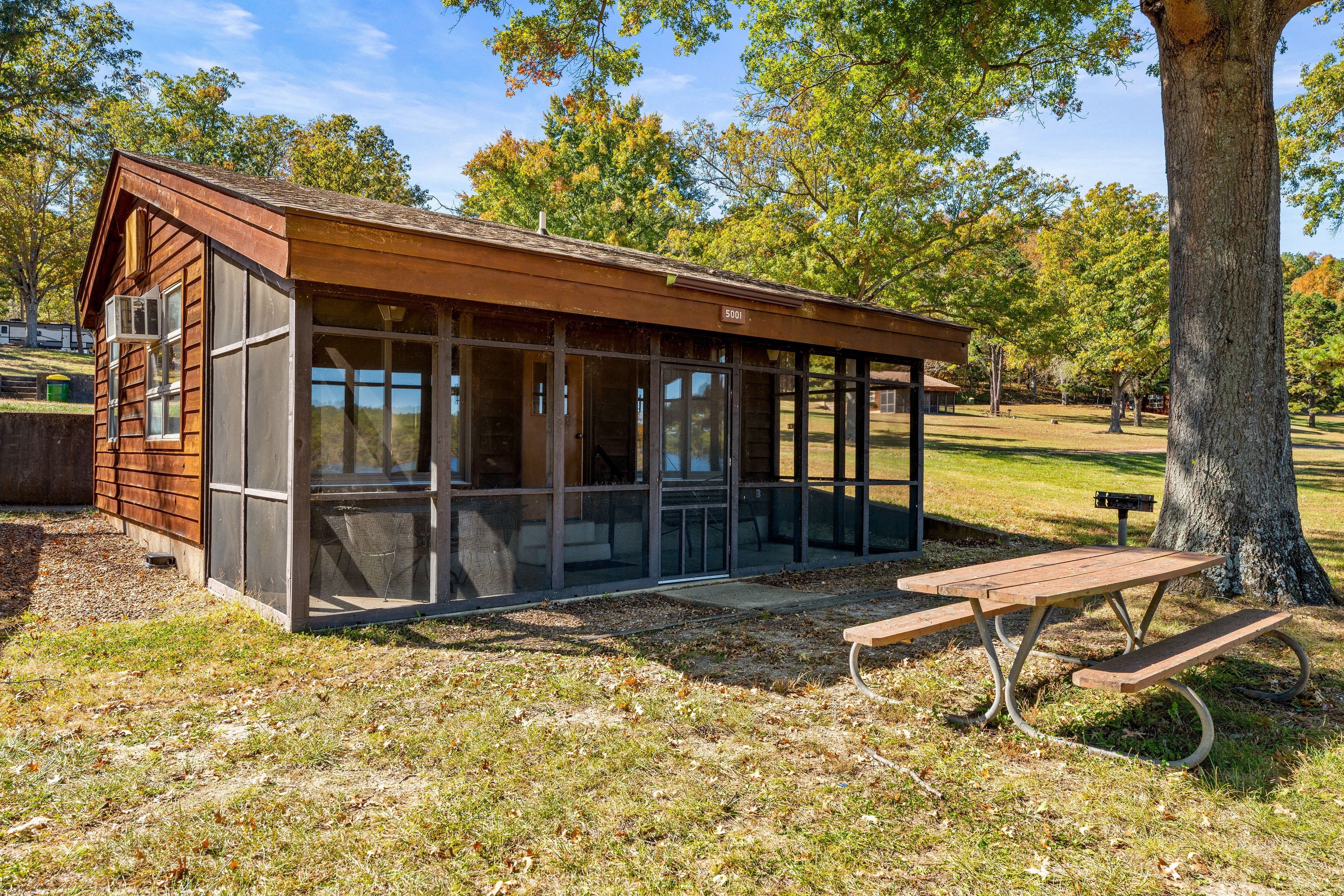 image Charming screened-in porch with seating, ideal for enjoying morning coffee or unwinding with nature views.