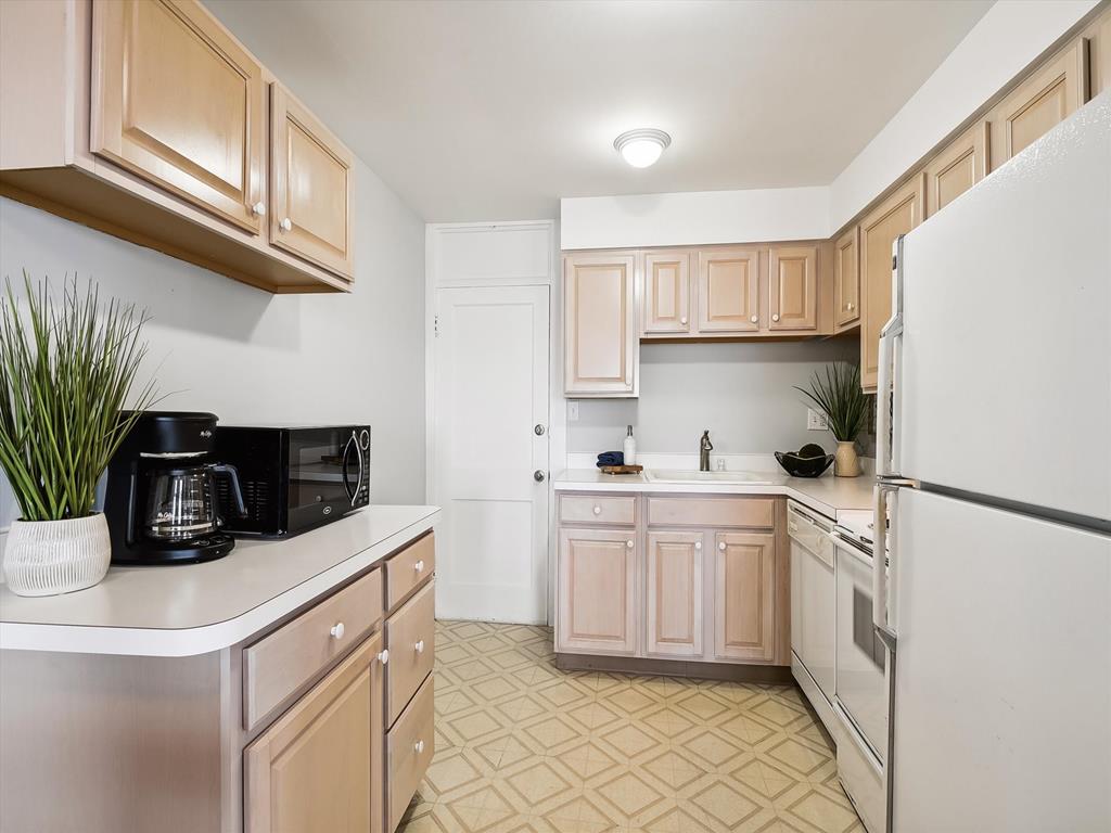 image A closer view of the kitchen, featuring a coffee maker, microwave, and a well-lit cooking space.
