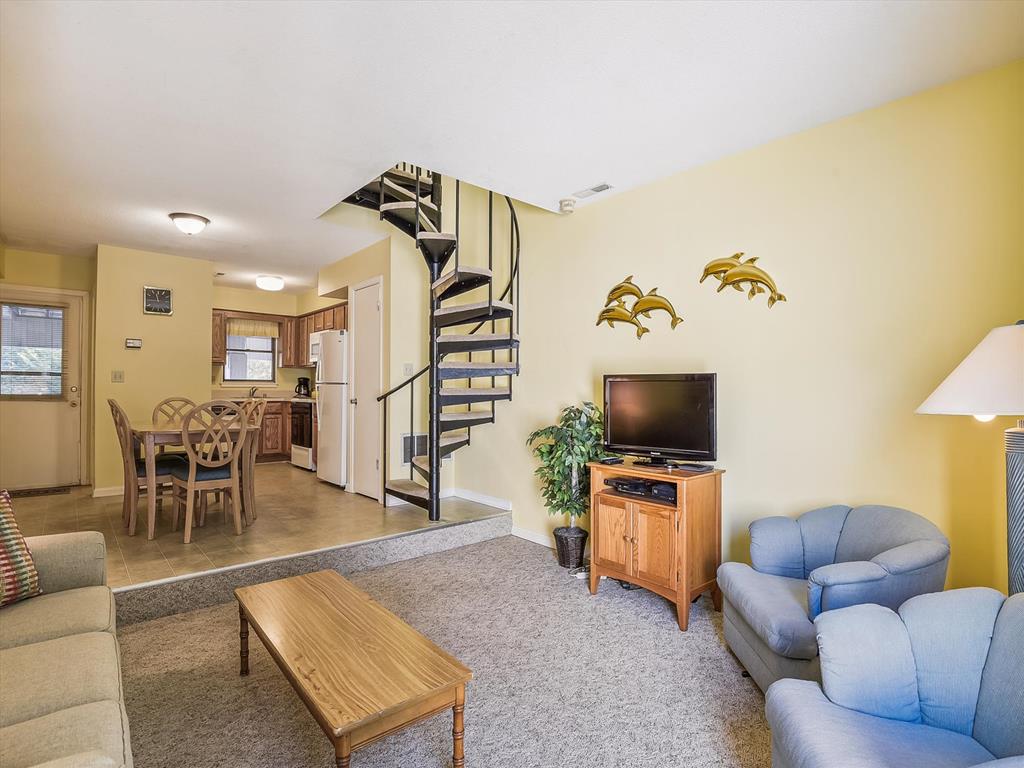 image Experience the inviting family-friendly layout of this townhome, showcasing a spiral staircase that leads to cozy living spaces and a full kitchen for all your dining needs.