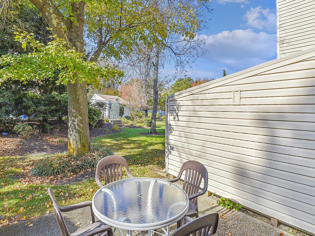 image Enjoy peaceful views of the landscaped community from your private outdoor seating space, ideal for relaxation after a day at the beach.