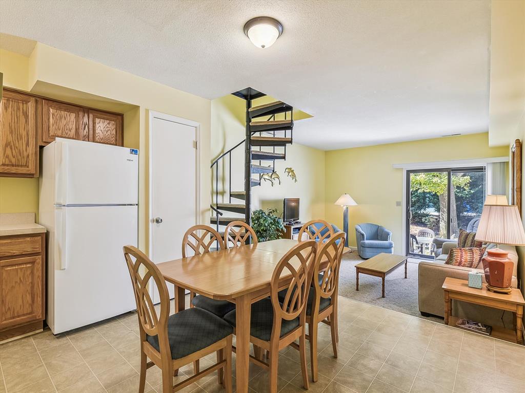 image This charming Bethany Beach townhome features a family-friendly layout with a cozy living space adorned with natural light, a spiral staircase, and direct access to a private terrace overlooking lush greenery.
