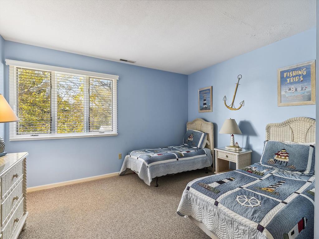image Embrace coastal charm in this serene bedroom, featuring cozy twin beds adorned with nautical décor, perfect for restful nights after sun-filled beach days.