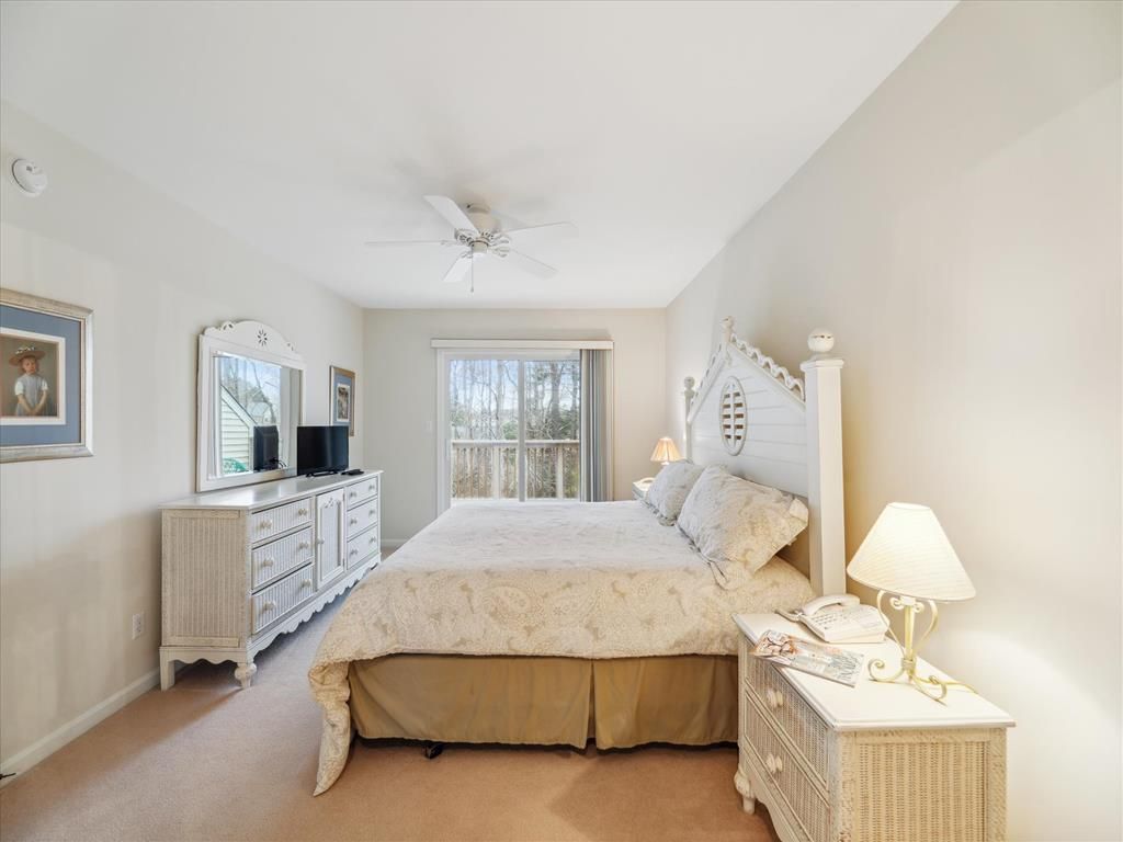 image This serene master bedroom features coastal-inspired decor, providing a relaxing retreat with access to a private balcony view.