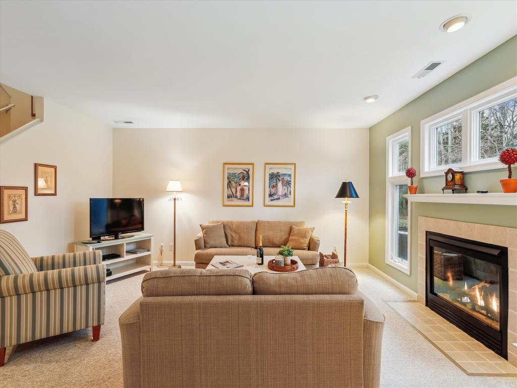 image Embrace comfort and warmth in the living room, highlighted by large windows and a charming fireplace, creating an inviting space for relaxation and leisure in this elegant townhome.