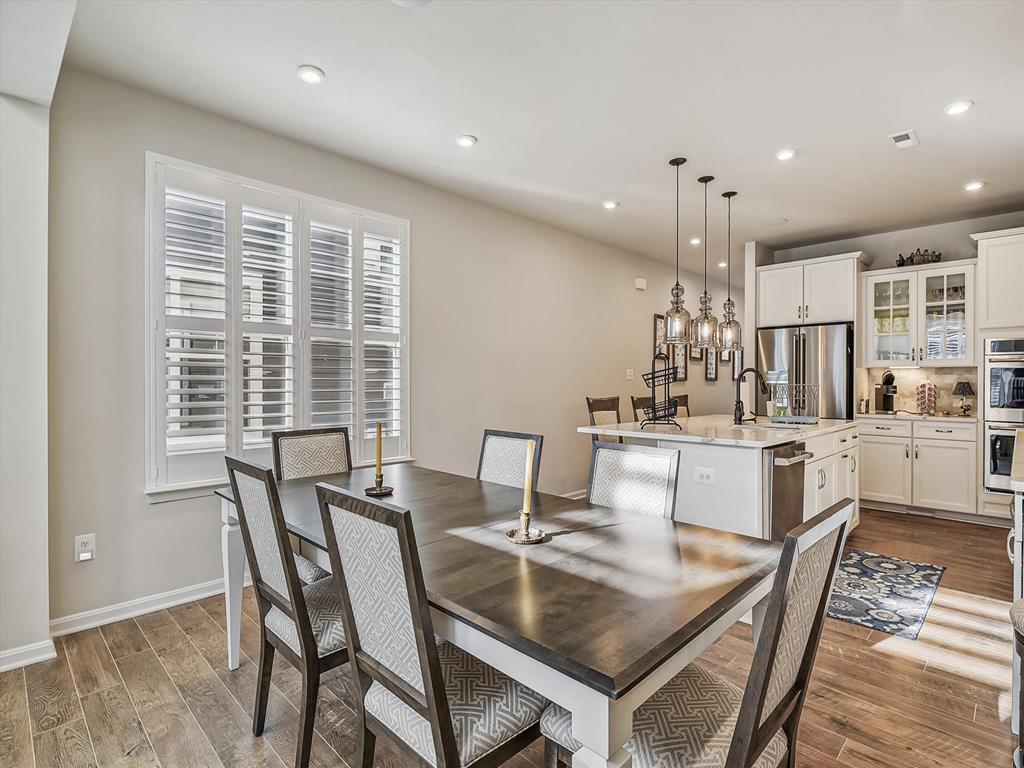 image This elegantly designed dining area features upgraded finishes and ample natural light, perfect for gatherings, with easy access to the gourmet kitchen and views of the luxurious amenities beyond.