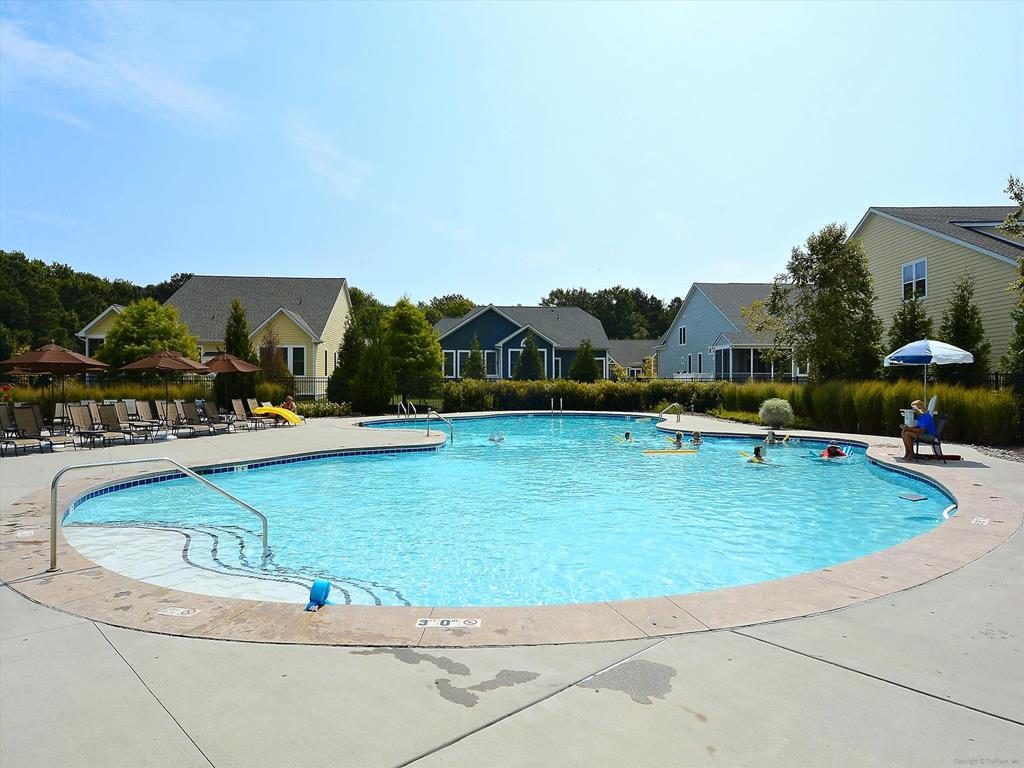 image Large community pool with crystal-clear water and ample space for swimming and soaking up the sun.