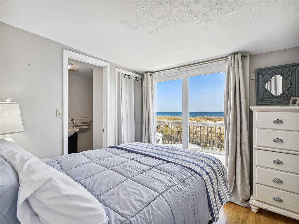 image Bright and airy bedroom with ocean views and cozy bedding.