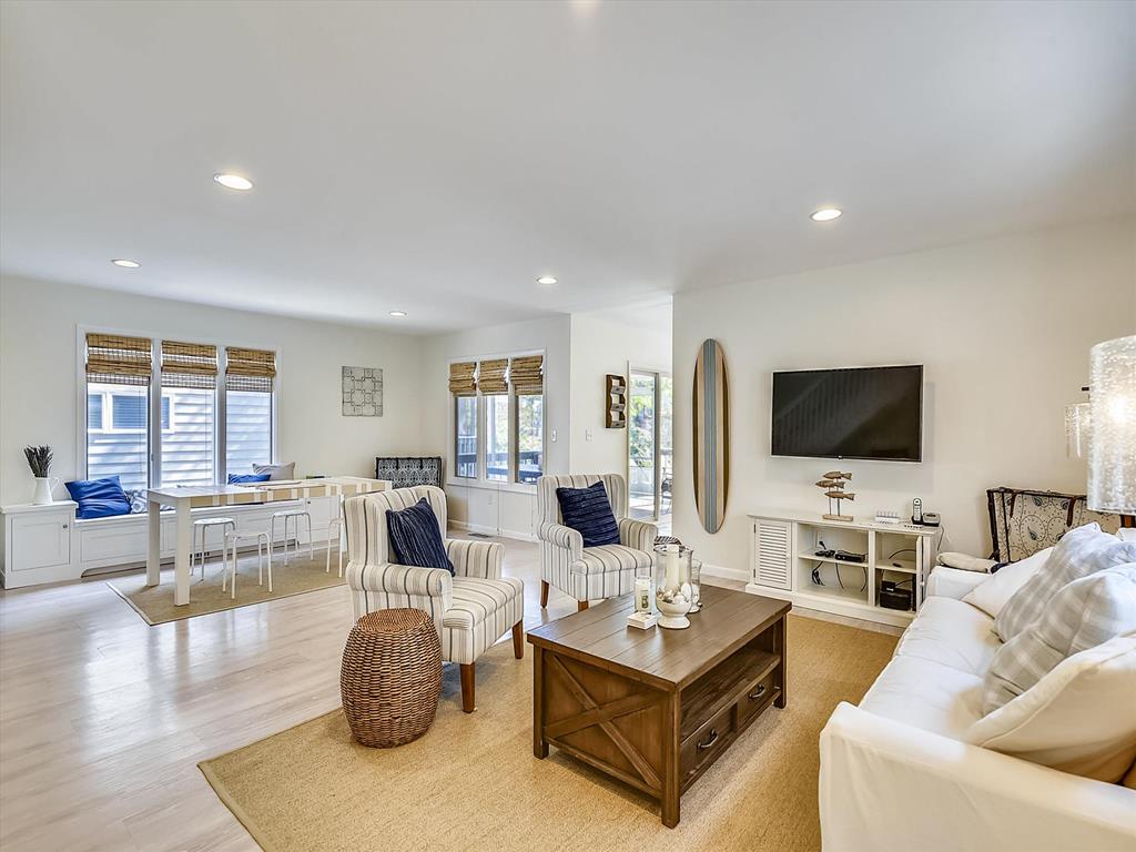 image In the open-concept living space, sunlit views from large windows accent the comfortable seating area, making it an ideal spot to unwind while enjoying a good book or watching shows on the Smart TV.