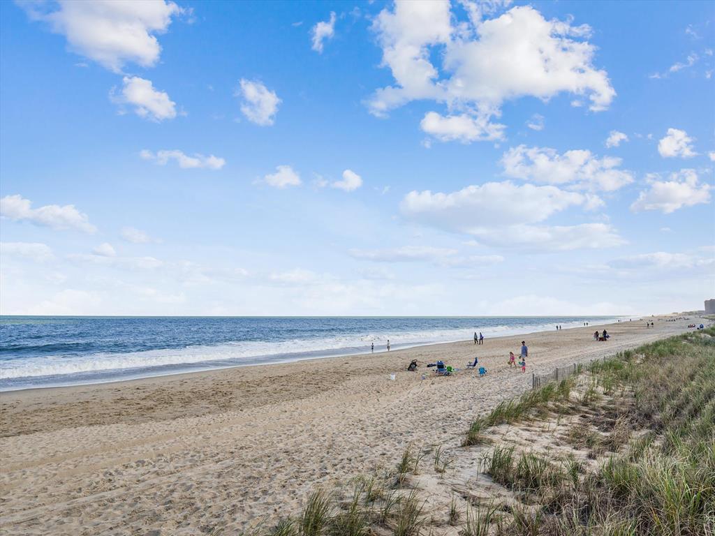 image The beach scene presents a stunning panorama of golden sands and the sparkling ocean, where guests can unwind and indulge in sunny days just moments away from their vacation rental.