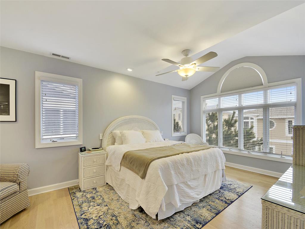image Relax in the serene master suite that boasts natural light and stylish decor, providing a peaceful retreat just steps from the beach.