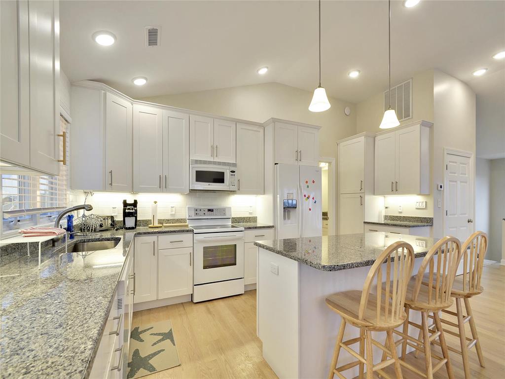 image The modern kitchen shines with updated appliances and ample space, perfect for entertaining after a day at the beach or enjoying ocean views.