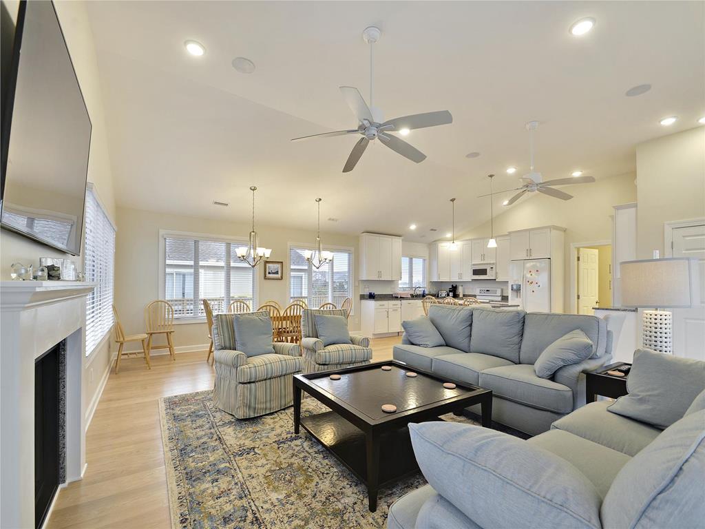image The open-concept living area features updated appliances and comfortable seating, perfect for family gatherings after a day at the beach.