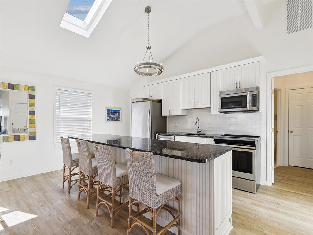 image The heart of the home, this renovated kitchen boasts a spacious 10' island that seamlessly connects to the open living area, perfect for entertaining.