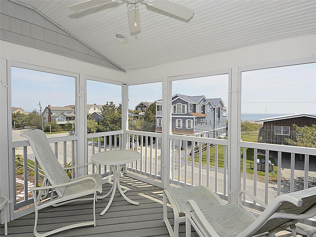 image Enjoy tranquil ocean views from your private screened porch, a perfect spot to unwind and take in the coastal breeze at this luxurious beach home.