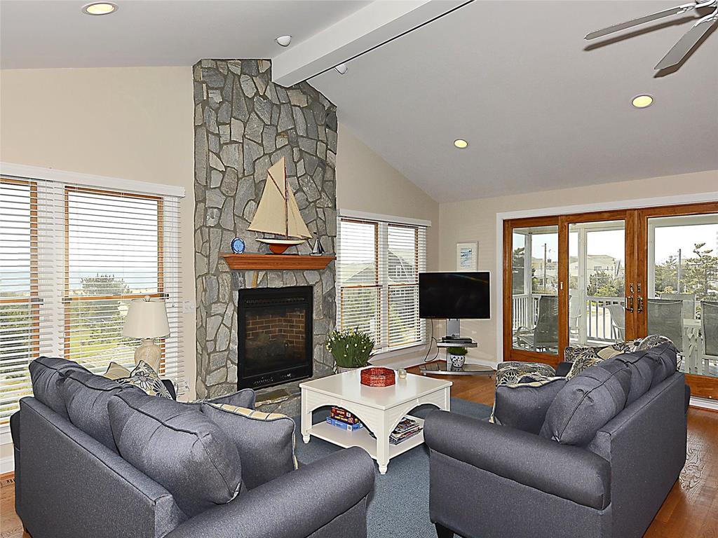 image Relax in the sophisticated living room, complete with a cozy fireplace and panoramic views of the ocean, effortlessly leading you to the expansive deck for seamless indoor-outdoor living.