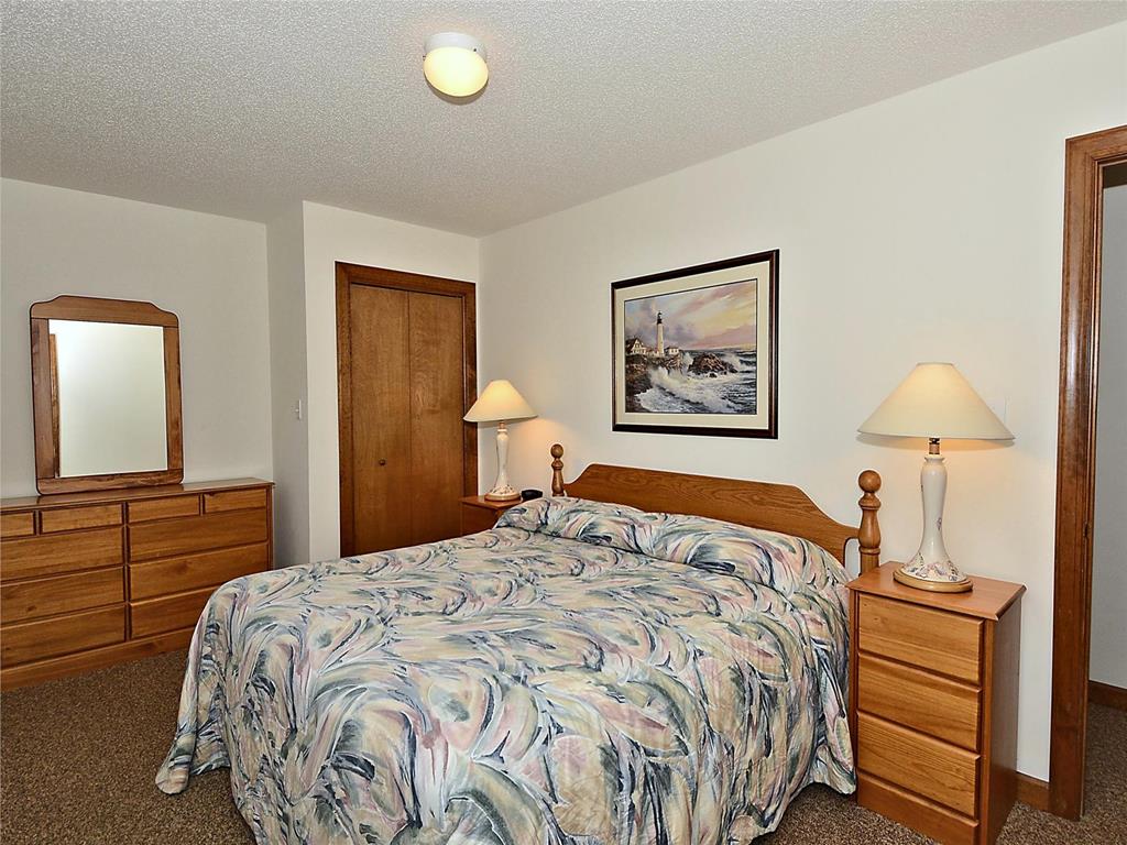 image Cozy bedroom with a queen-sized bed, warm decor, and ample storage.