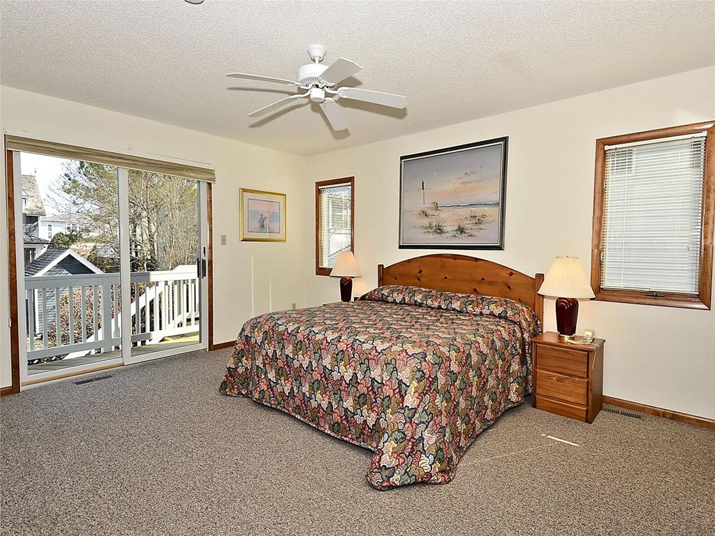image Comfortable bedroom with a queen bed, private balcony access, and large windows offering plenty of sunlight and a refreshing coastal breeze.