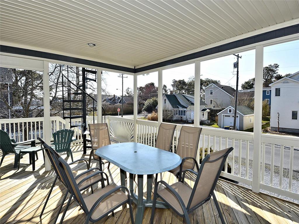 image Screened-in porch with a dining set, offering the perfect spot to enjoy meals outdoors while soaking in the coastal atmosphere.