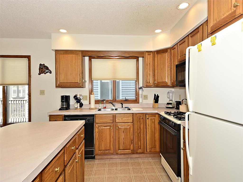 image Fully equipped kitchen with warm wood cabinetry, modern appliances, and ample counter space—ideal for preparing meals for the whole group.