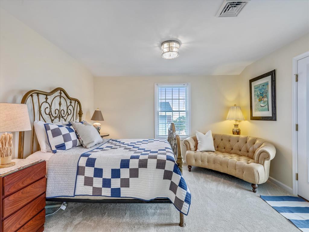 image A beautifully styled bedroom featuring a quilted bedspread, cozy seating, and a serene ambiance for relaxation.